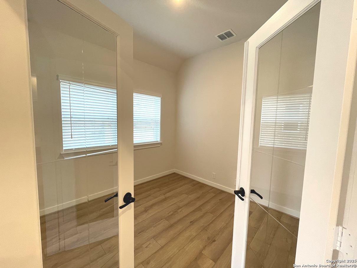 116 Radnor Road New Braunfels, TX 78130 - Photo 10 of 26 a view of an empty room with wooden floor and a window