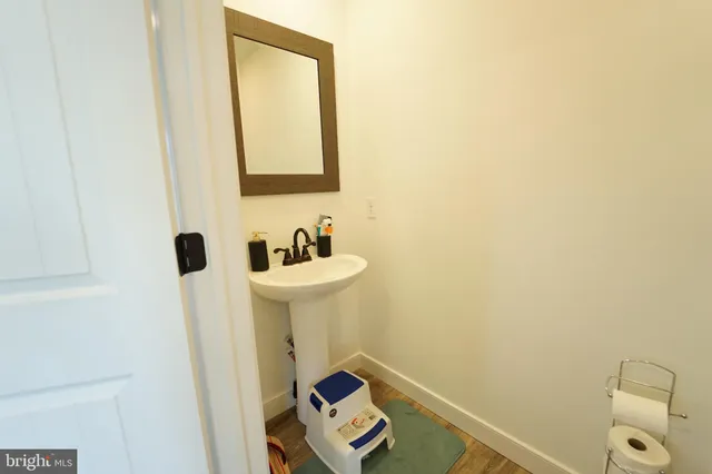 a kitchen with stainless steel appliances kitchen island granite countertop a refrigerator a stove a sink a dining table and chairs with wooden floor