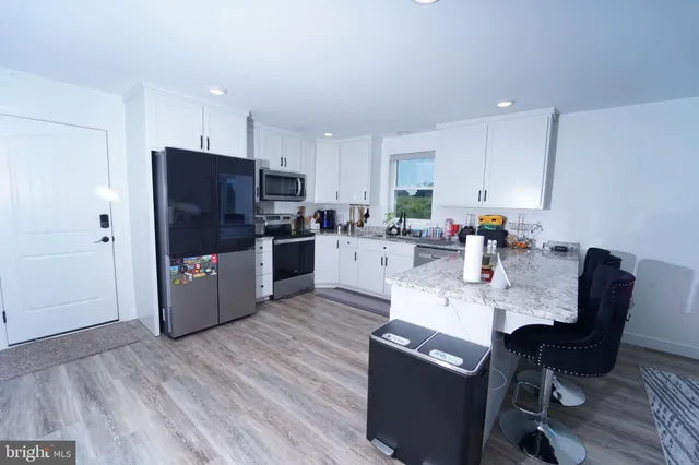 a kitchen with granite countertop a refrigerator stove and sink