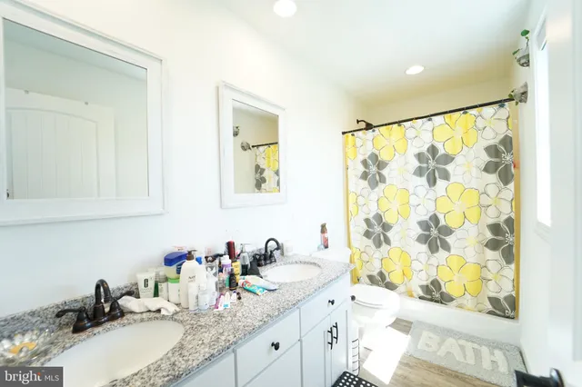 a spacious bathroom with a granite countertop sink and a mirror
