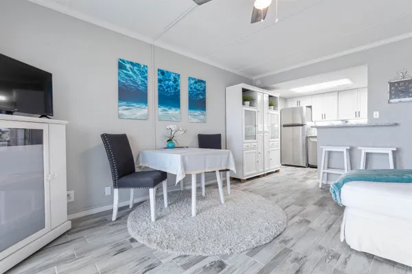 a living room with furniture a flat screen tv and kitchen view