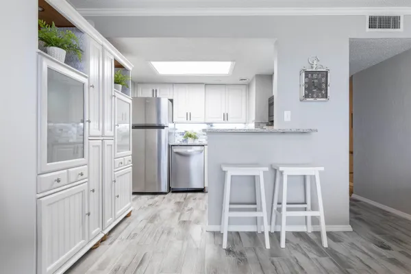 a kitchen with white cabinets and stainless steel appliances