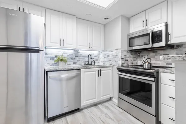 a kitchen with stainless steel appliances granite countertop a stove a microwave and a refrigerator