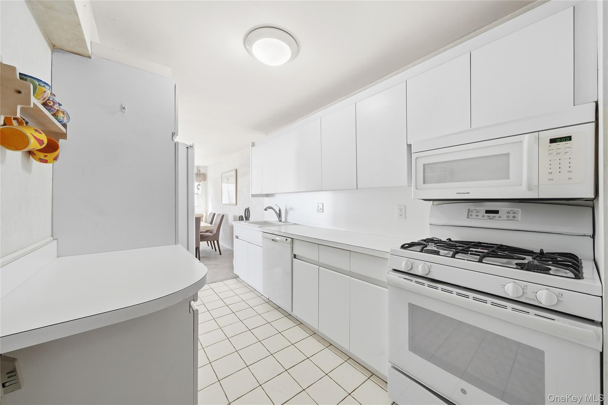 750 Shore Road, Unit 3O Long Beach, NY 11561 - Photo 9 of 23 a kitchen with a sink stove and white cabinets