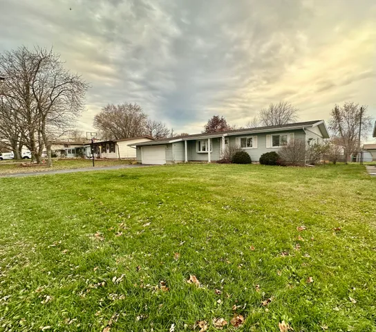 a view of a house with a big yard and large trees