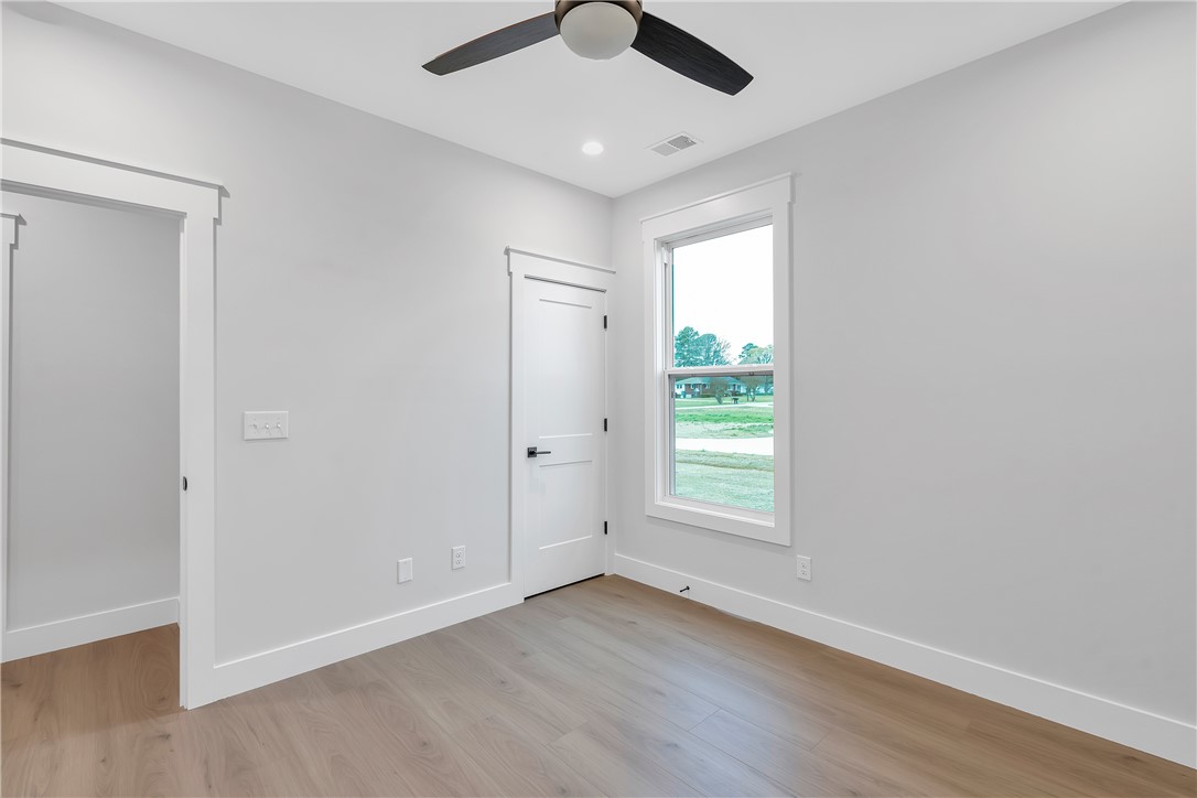 4554 Flat Rock Road Iva, SC 29655 - Photo 19 of 32 A well-lit bedroom features durable hardwood flooring and a functional ceiling fan.