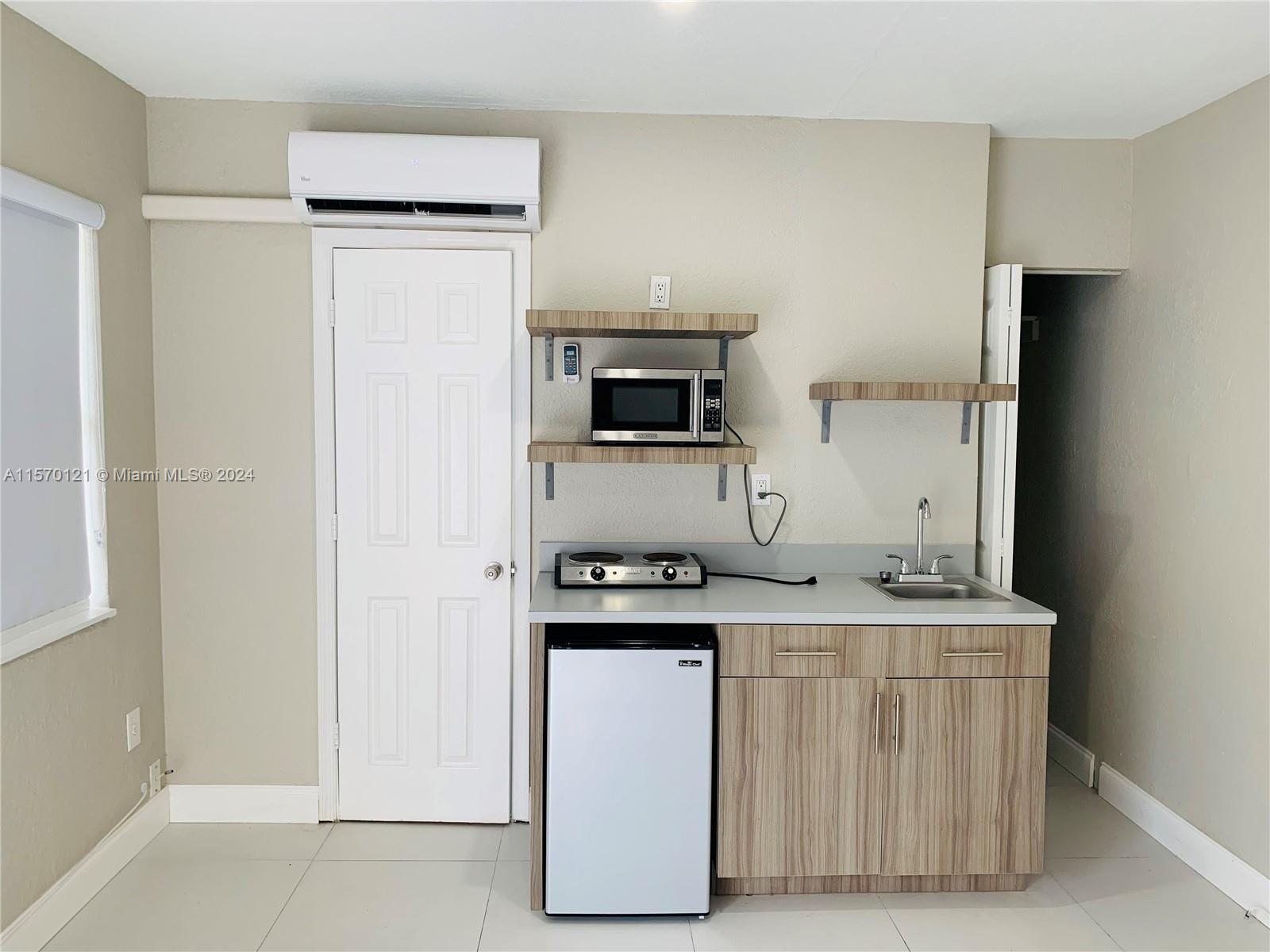 1265 Southwest 6th Street, Unit 13 Miami, FL 33135 - Photo 2 of 7 a kitchen with a stove and a microwave
