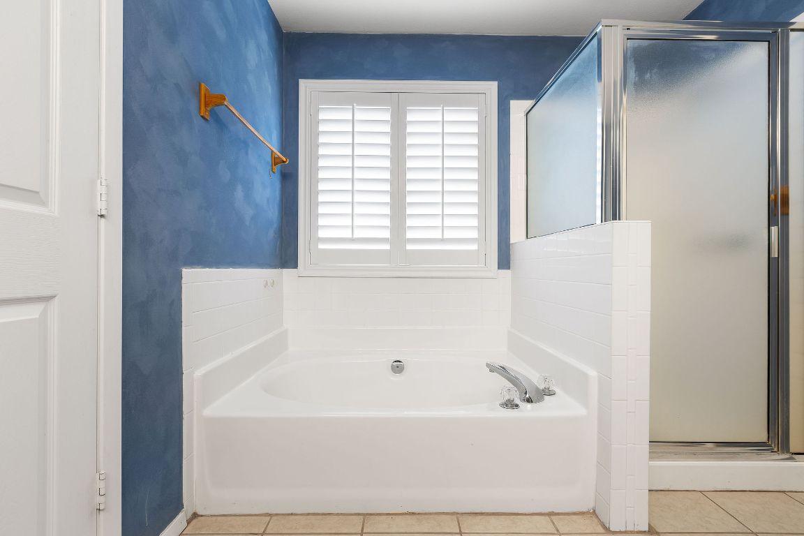 112 Amherst Court Kyle, TX 78640 - Photo 16 of 38 a bath tub sitting in a bathroom next to a window