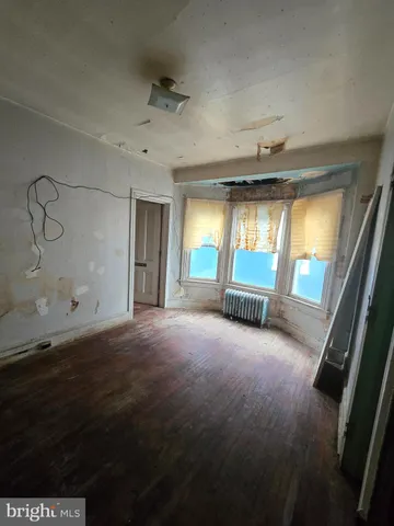 a view of an empty room with a fireplace and a window