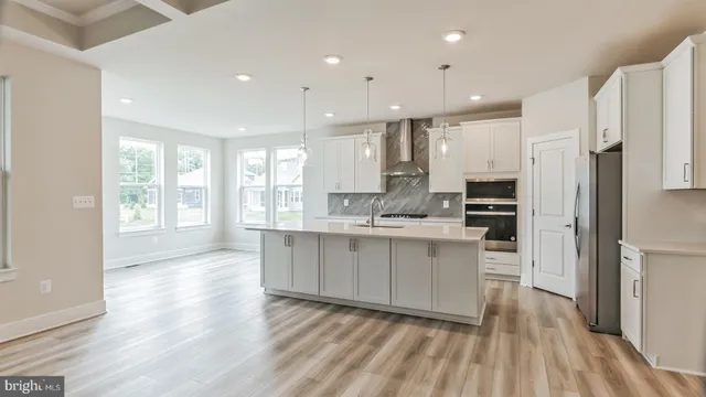 a kitchen with stainless steel appliances granite countertop a refrigerator oven a sink dishwasher and a stove with wooden floor