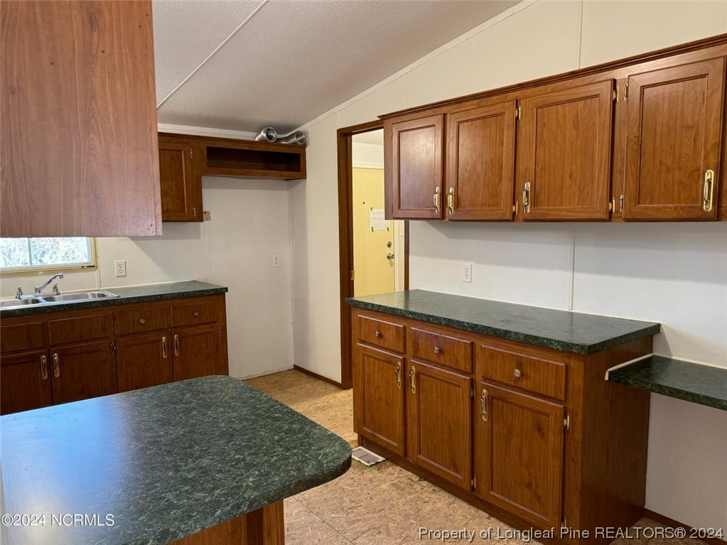 2352 County Line Road Cameron, NC 28326 - Photo 26 of 38 a kitchen with granite countertop wooden cabinets and a granite counter top
