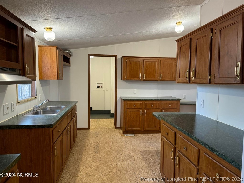 2352 County Line Road Cameron, NC 28326 - Photo 30 of 38 a kitchen with kitchen island granite countertop a stove top oven microwave and cabinets