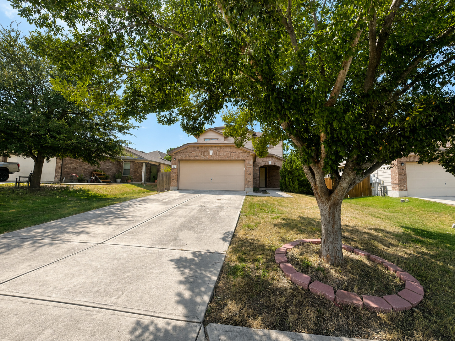 122 Rummel Drive Kyle, TX 78640 - Photo 2 of 18 A neatly maintained lawn and driveway lead to a charming brick residence.