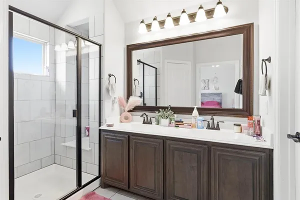a bathroom with double vanity and a mirror