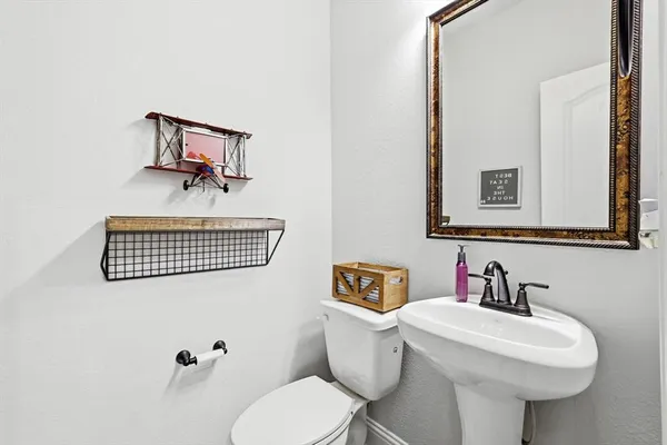 a bathroom with a toilet sink and mirror