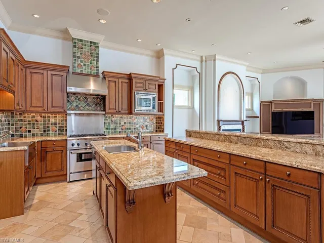 a large kitchen with stainless steel appliances granite countertop a sink and a stove