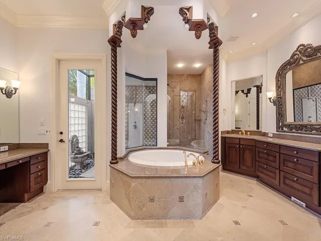 a spacious bathroom with a tub sink a toilet a mirror and shower
