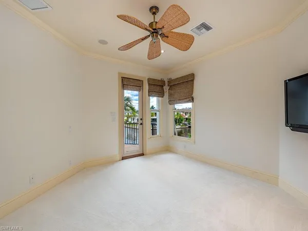 en empty room with windows and ceiling fan