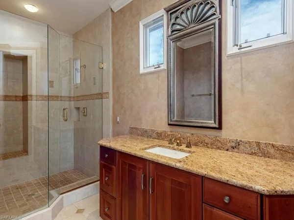a bathroom with a granite countertop sink mirror and shower