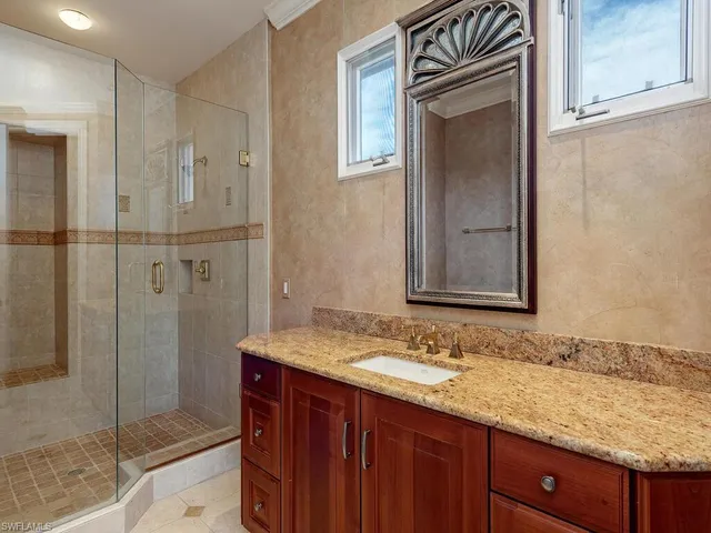 a bathroom with a granite countertop sink mirror and shower