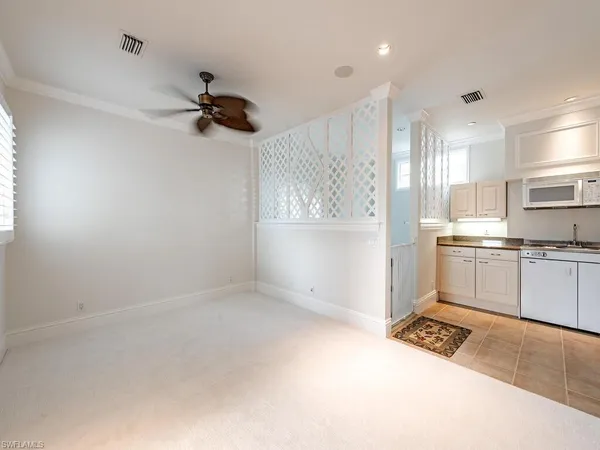 a kitchen with white cabinets and white appliances
