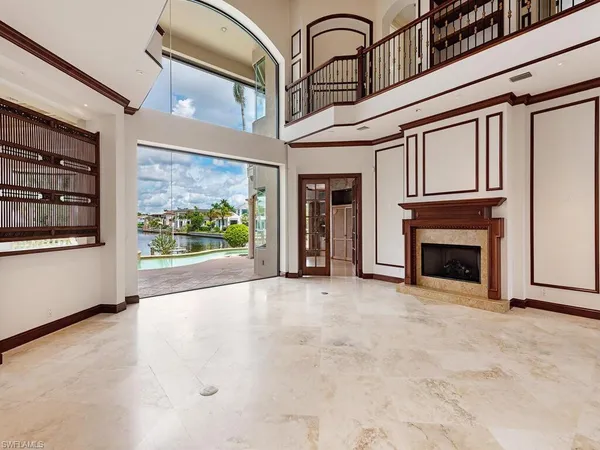 a view of an empty room with a fireplace and a window