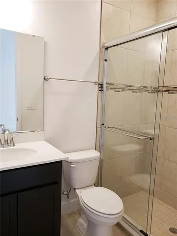 a front view of a building with garden and trees