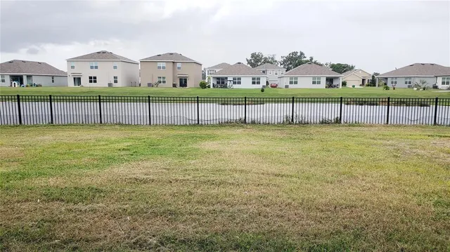 a view of a big yard with a small yard and wooden fence