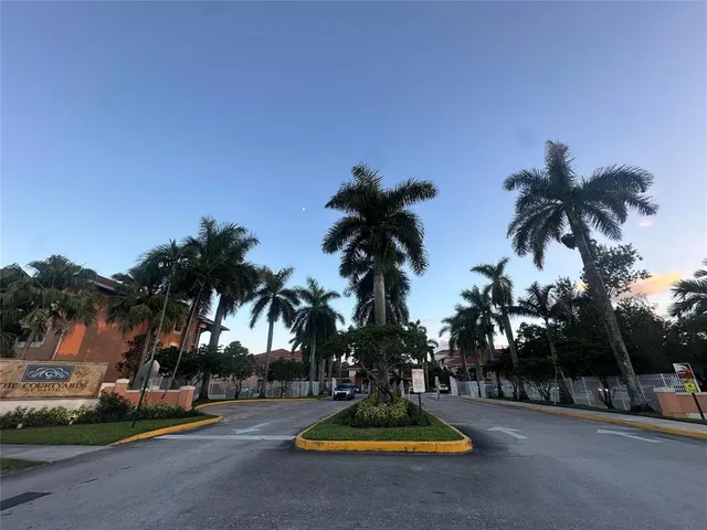 a palm tree sitting in front of a house with a yard