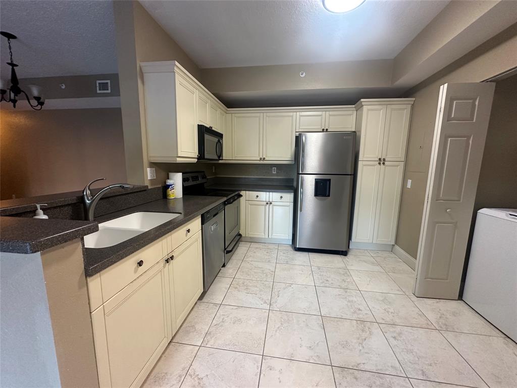 6928 Southwest 39th Street, Unit 207 Fort Lauderdale, FL 33314 - Photo 7 of 21 a kitchen with a sink a refrigerator and cabinets