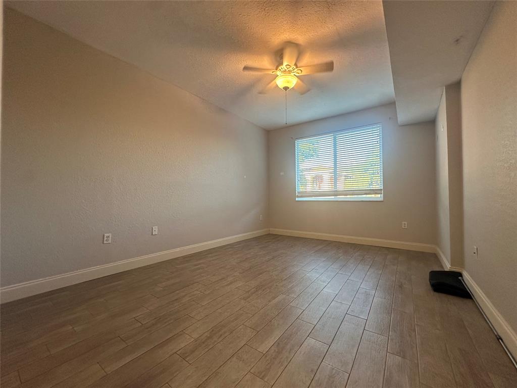 6928 Southwest 39th Street, Unit 207 Fort Lauderdale, FL 33314 - Photo 10 of 21 an empty room with wooden floor and windows
