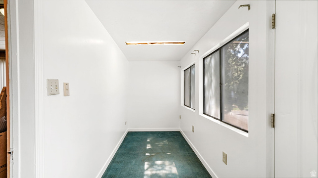 44 Shriver Street Eureka, UT 84628 - Photo 4 of 43 Corridor with white painted walls, two rectangular windows with black frames, and green carpet flooring