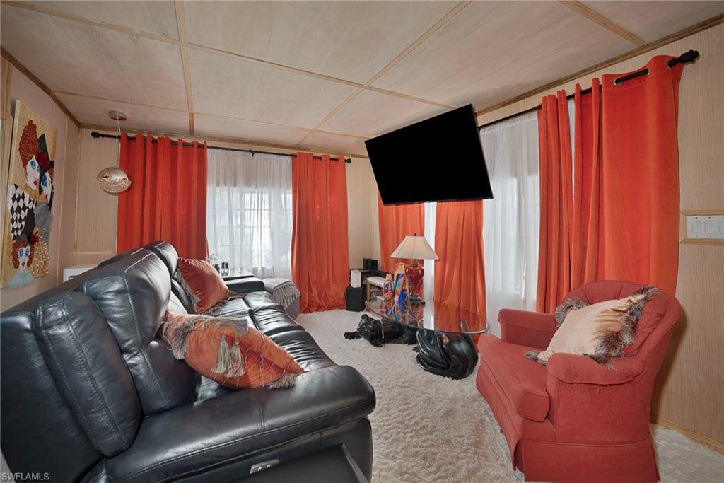 777 Walkerbilt Road, Unit 34 Naples, FL 34110 - Photo 4 of 22 a living room with furniture a flat screen tv and a window