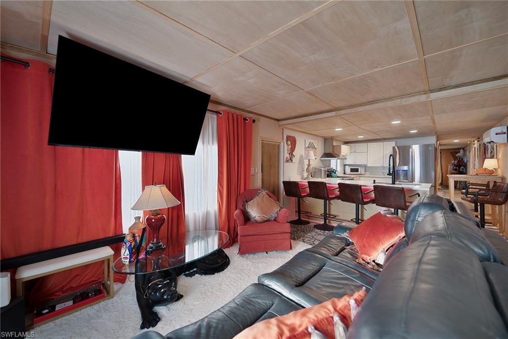 777 Walkerbilt Road, Unit 34 Naples, FL 34110 - Photo 5 of 22 a living room with lots of furniture and a flat screen tv