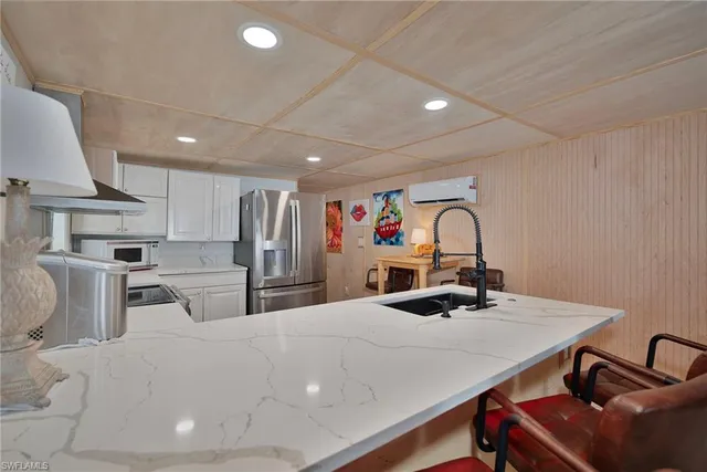a kitchen with stainless steel appliances kitchen island granite countertop a sink a stove and chairs