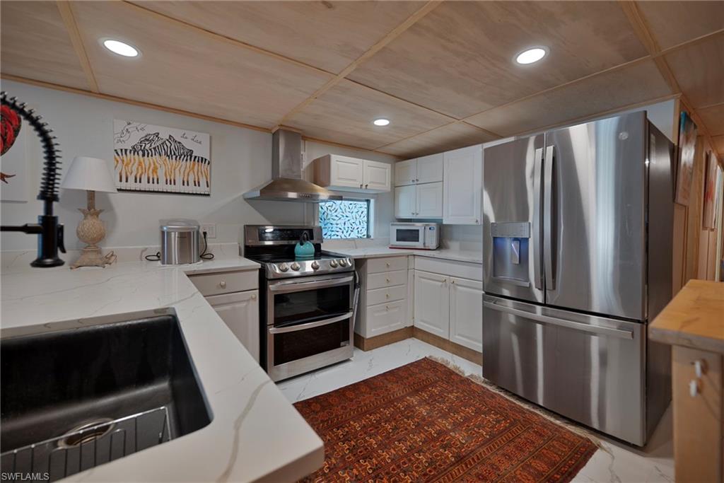 777 Walkerbilt Road, Unit 34 Naples, FL 34110 - Photo 7 of 22 a kitchen with stainless steel appliances granite countertop a refrigerator stove and sink