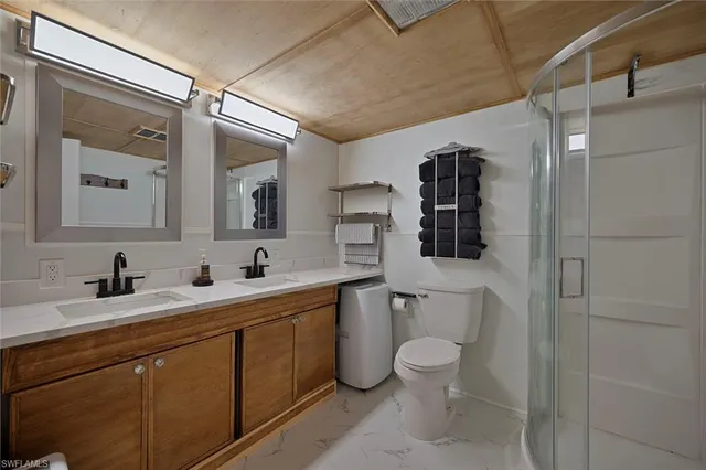 a bathroom with a toilet sink double vanity and mirror