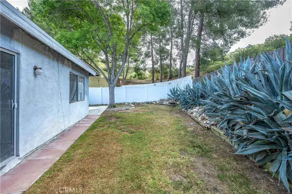 front view of a house with a yard and an trees