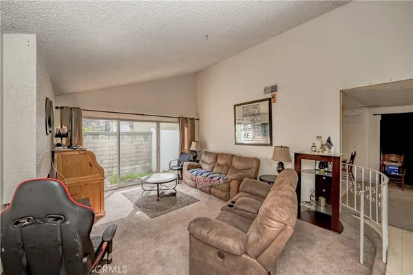 a living room with furniture a flat screen tv and large window