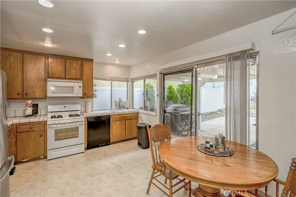 a kitchen with a stove a sink a refrigerator dining table and chairs