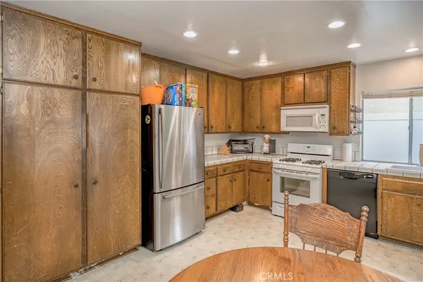 a kitchen with a refrigerator a stove top oven a sink and cabinets