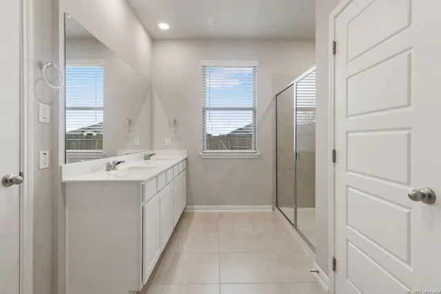 a bathroom with a sink a mirror and a shower