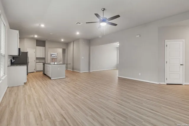 a view of empty room with wooden floor and window