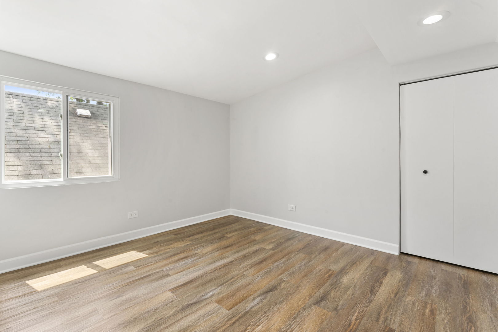 8746 South Wood Street Chicago, IL 60620 - Photo 18 of 27 an empty room with wooden floor and windows