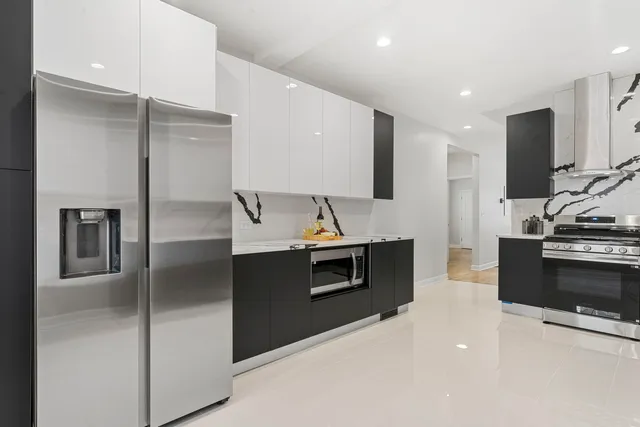 a kitchen with stainless steel appliances kitchen island granite countertop a stove and a refrigerator