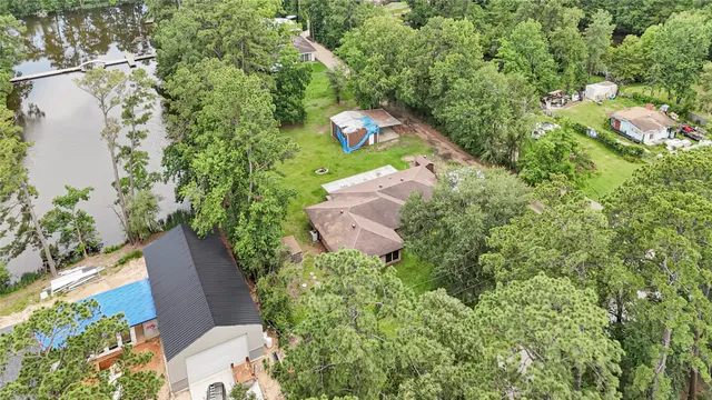 an aerial view of a house with a yard and lake view