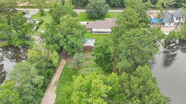 an aerial view of residential house with outdoor space and trees all around