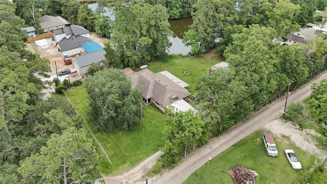 an aerial view of residential house with outdoor space and trees all around