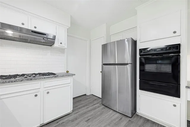 a kitchen with stainless steel appliances granite countertop a refrigerator and a stove