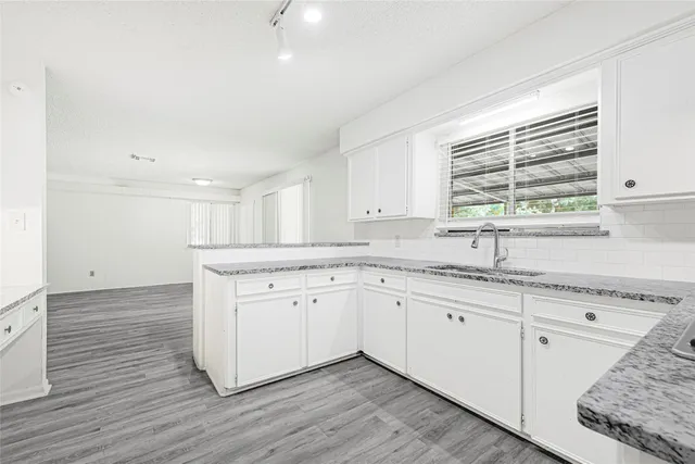 a kitchen with granite countertop white cabinets and white appliances